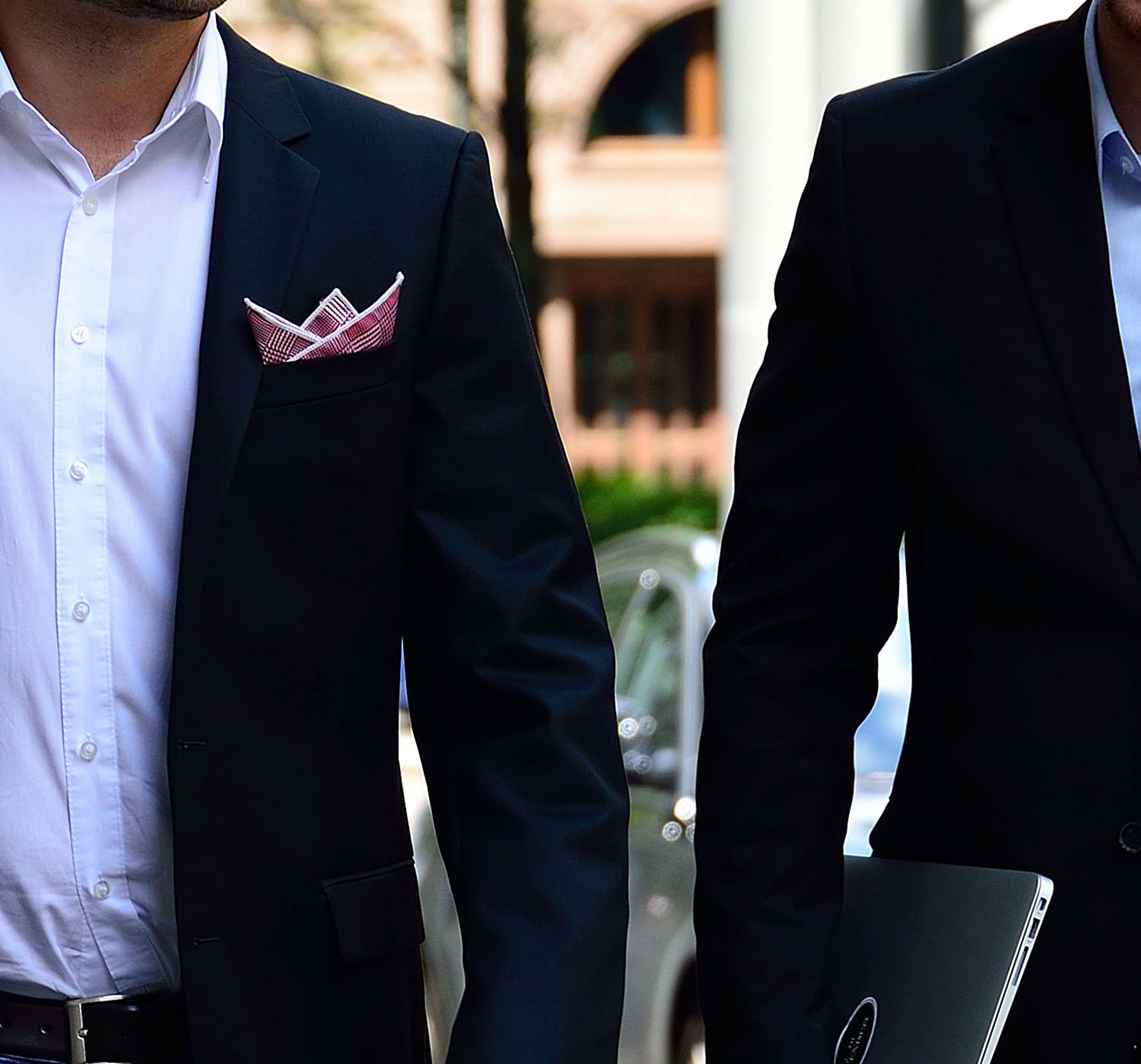 Monumental building with two men in front and gorgeous pocket squares by di Venisco.